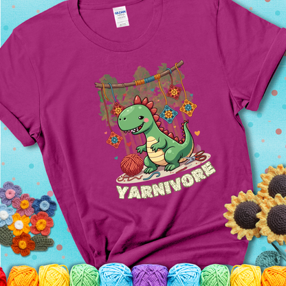 Magenta t-shirt shows a cute green dinosaur with yarn ball and granny squares, text “Yarnivore”, a fun crochet shirt for dino and yarn fans.