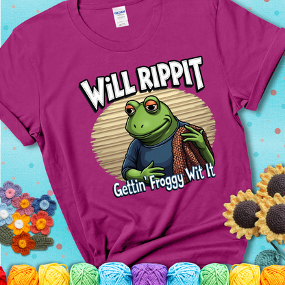 Cool frog holding a yarn blanket. Text reads: “Will Rippit Gettin’ Froggy Wit It.” A hip and humorous crochet magenta tee for yarn lovers with rhythm.