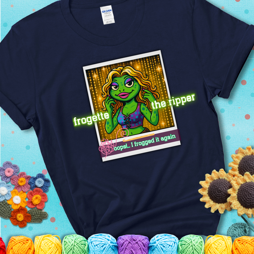 Retro-styled illustration of a glamorous green frog in a sparkly outfit, labeled "Frogette the Ripper" with the phrase “Oops! I frogged it again” below, referencing both crochet and pop culture showing a navy blue tee with a teal sunflower background