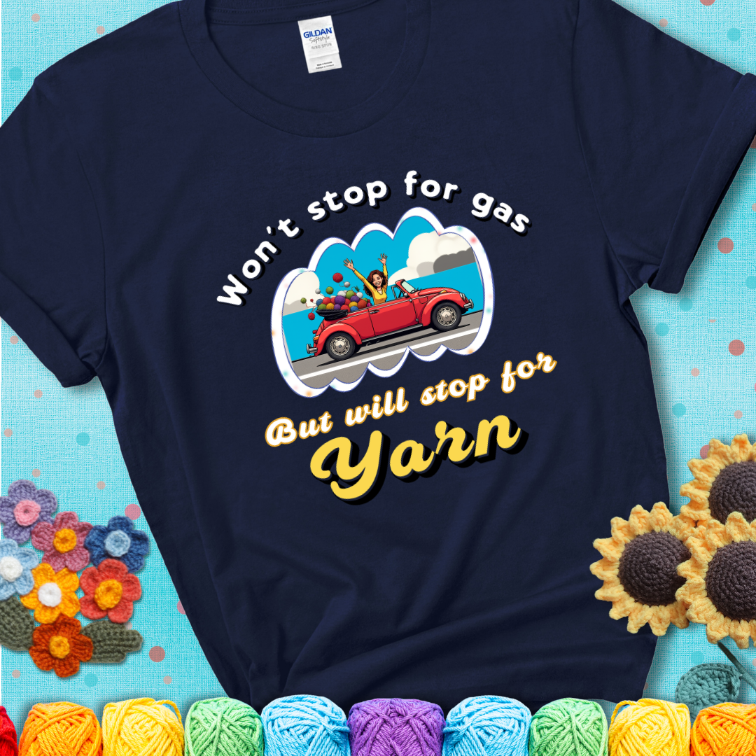 Navy blue t-shirt with a woman driving a red convertible filled with yarn and the phrase “Won't Stop For Gas But Will Stop For Yarn.”