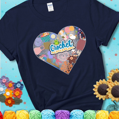 A heart filled with colorful crochet essentials including yarn, hooks, scissors, notions, and handmade items, with the word "Crochet" prominently in the center of a navy blue t-shirt.