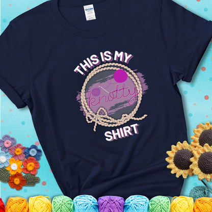 Navy t-shirt with the phrase “This is My Knotty Shirt” inside a rope circle, featuring a yarn ball and crochet hook forming the word “knotty.”