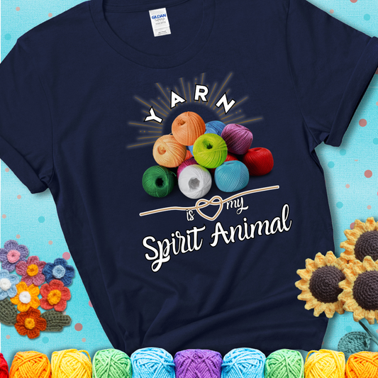 Stack of colorful yarn balls with radiant glow. Text reads: “Yarn Is My Spirit Animal.” A calming and colorful tee for fiber lovers who find zen in stitching, showing a navy blue tee with a teal sunflower background