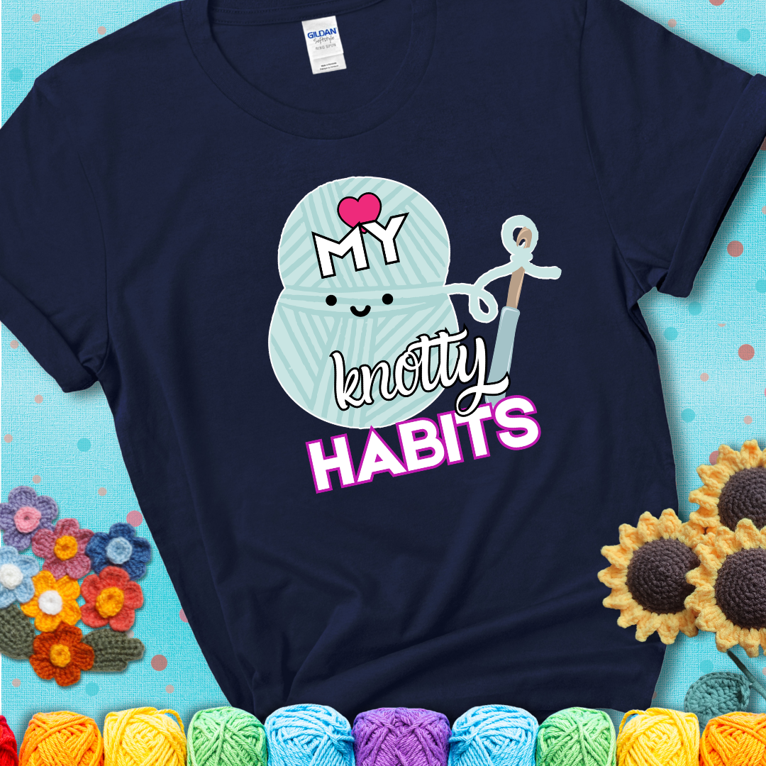 Smiling yarn ball and hook with text “Love My Knotty Habits” - cute crochet shirt with playful design for makers, showing a navy blue tee with a teal sunflower background