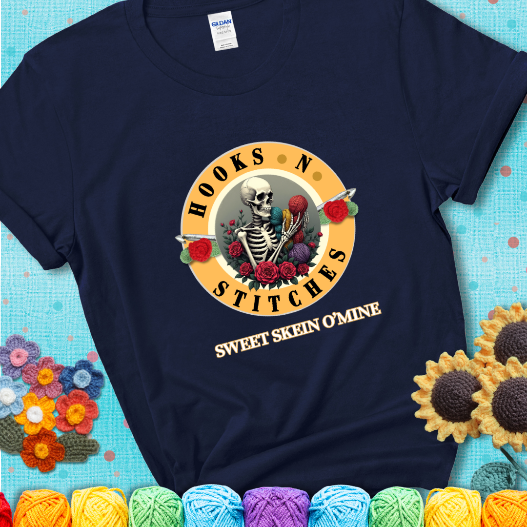 Navy t-shirt with a skeleton holding colorful yarn, roses, crochet hooks, and the phrases “Hooks ’N Stitches” and “Sweet Skein O’Mine.”