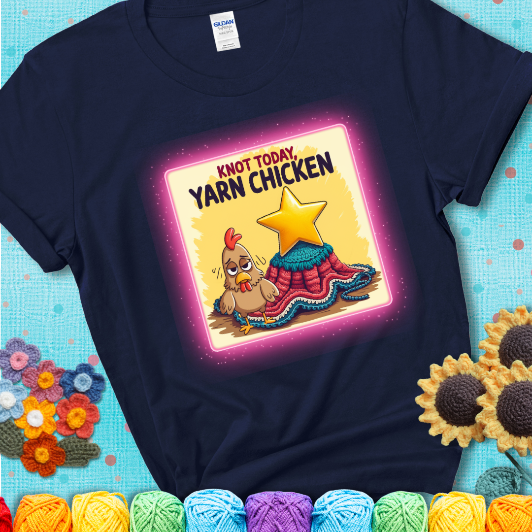 A navy blue t-shirt showing a frazzled cartoon chicken stands next to a nearly-finished project with minimal yarn left, with the phrase “Knot Today, Yarn Chicken” above.