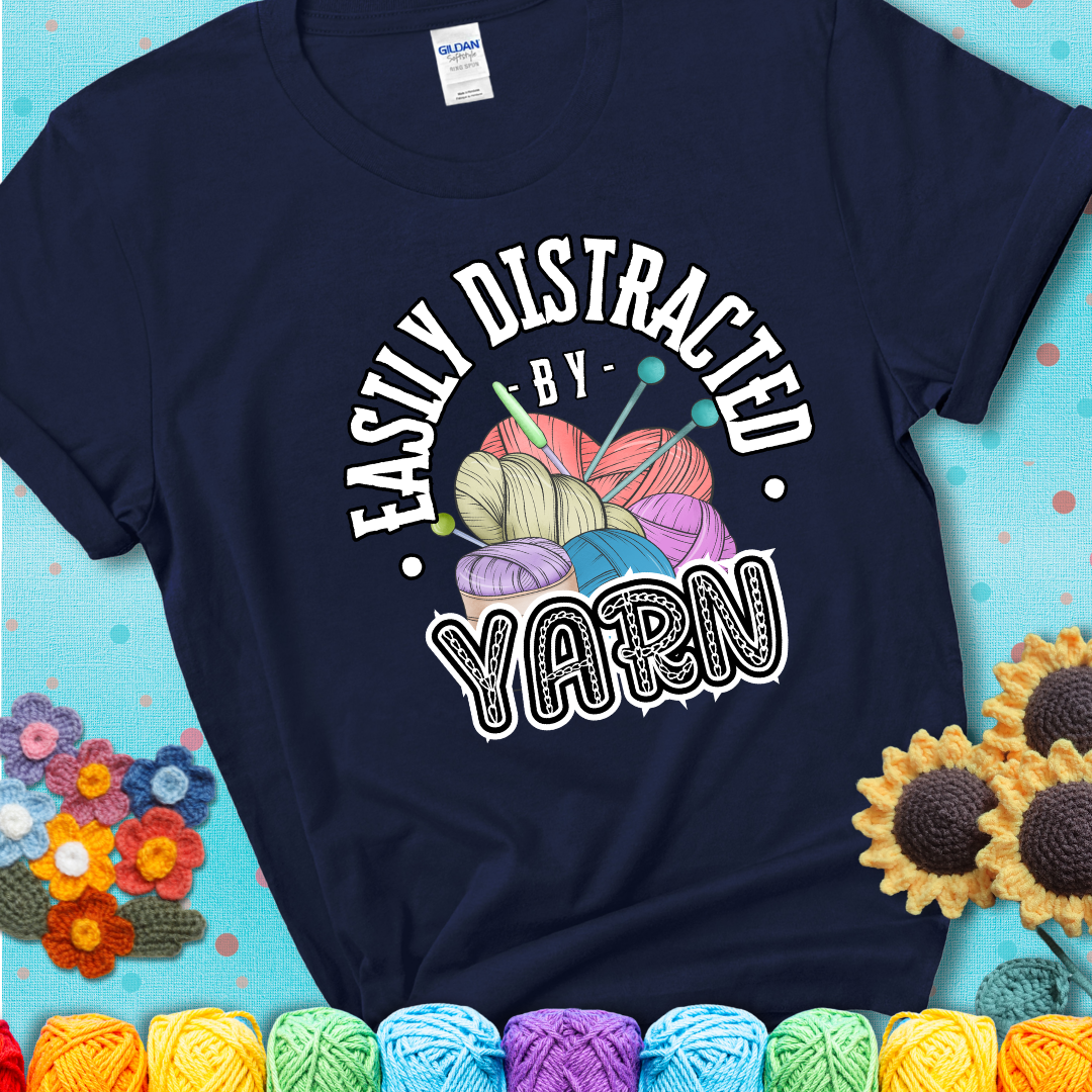 If yarn steals your focus every Design reads 'Easily Distracted By Yarn', perfect crochet gift for yarn lovers; showing a navy blue tee with a teal sunflower background