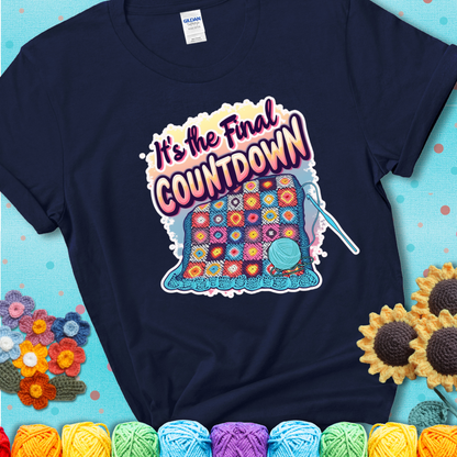 Navy t-shirt with a colorful crochet blanket in progress, blue yarn ball, crochet hook, and the phrase “It’s The Final Countdown.”
