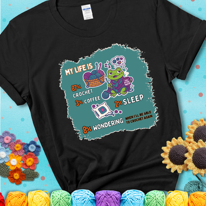 Black t-shirt with a crocheting frog, coffee, yarn, and text showing a playful life breakdown: 87% crochet, 3% coffee, 2% sleep, 8% wondering when to crochet again.