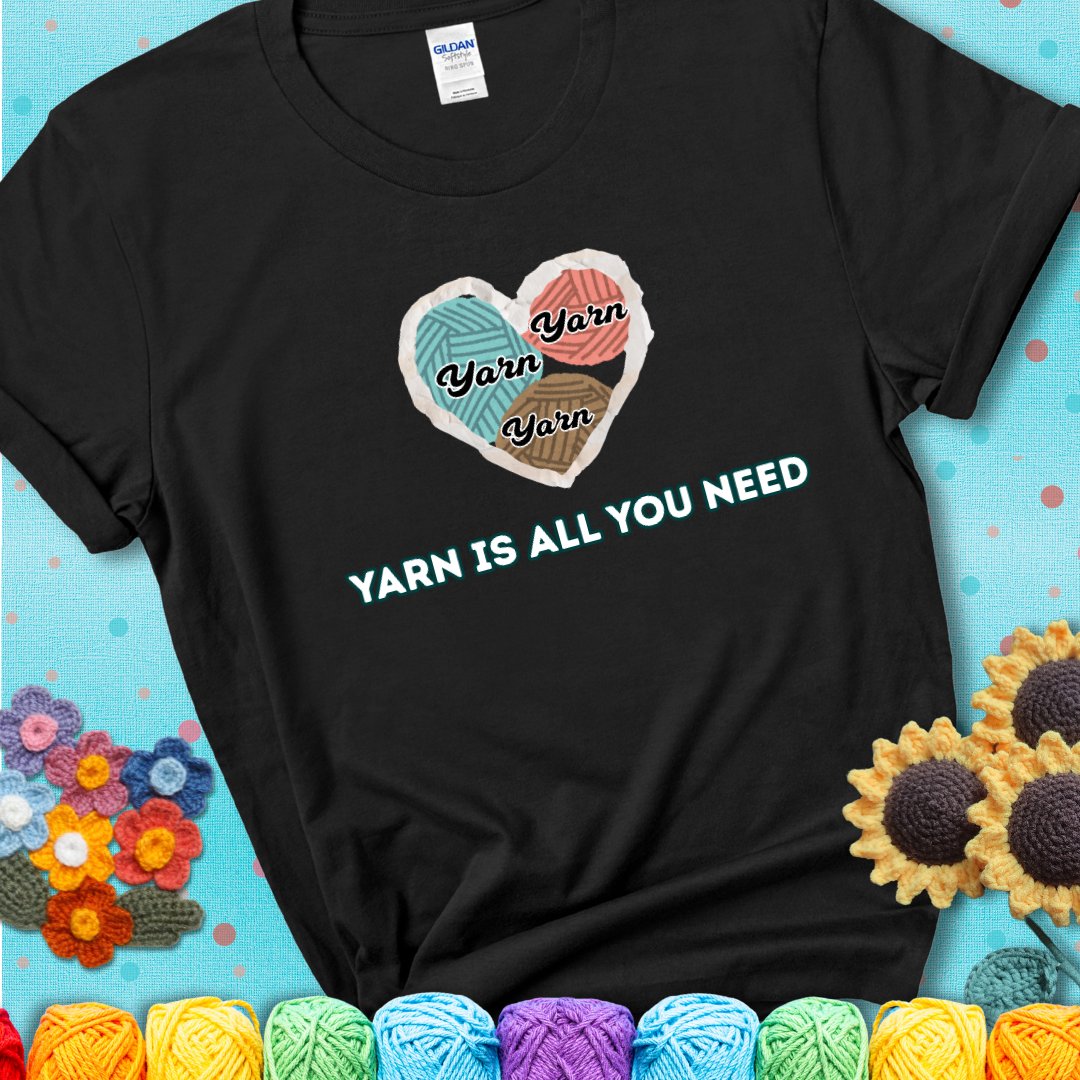 Black t-shirt with a colorful heart made of yarn textures and the phrase “Yarn Is All You Need” in retro lettering.