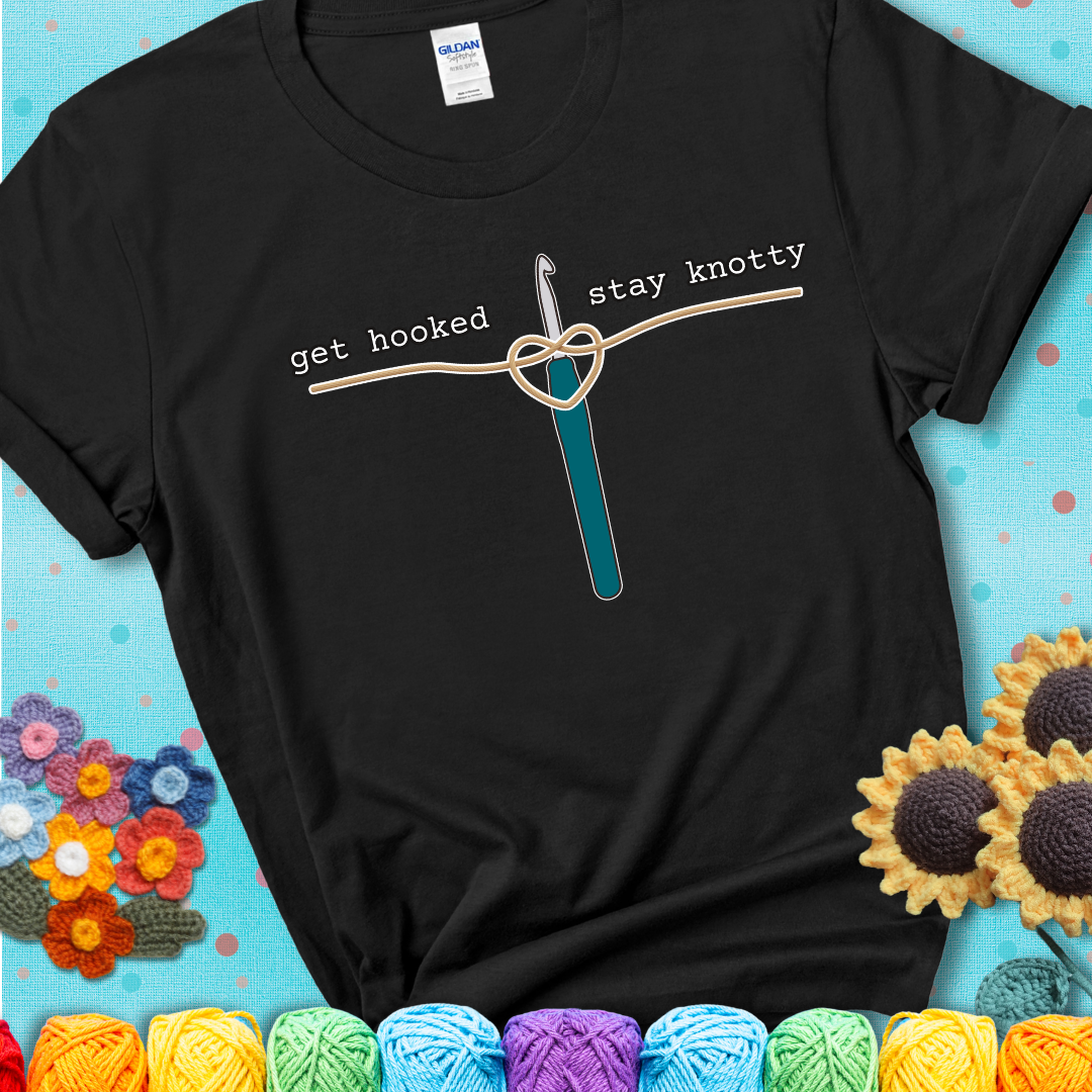 Hooked on yarn? Same Design reads 'Get Hooked, Stay Knotty' , perfect crochet gift for yarn lovers, showing a black tee with a teal sunflower background