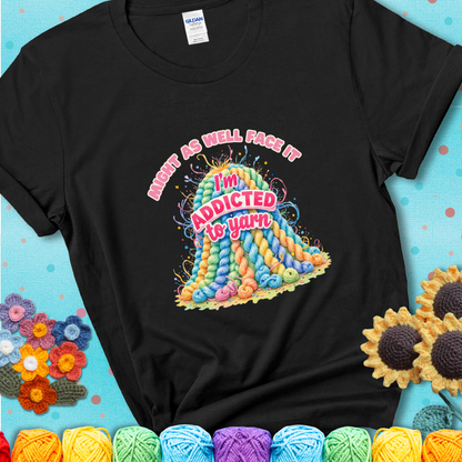 Black t-shirt with a colorful mountain of pastel yarn hanks and the phrase “Might As Well Face It, I’m Addicted To Yarn” in pink and red lettering.
