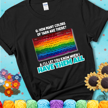 Black t-shirt with rainbow skeins of yarn stacked in color gradient with playful question: “How many colors of yarn are there?” Answer: “I'll let you know when I have them all.”