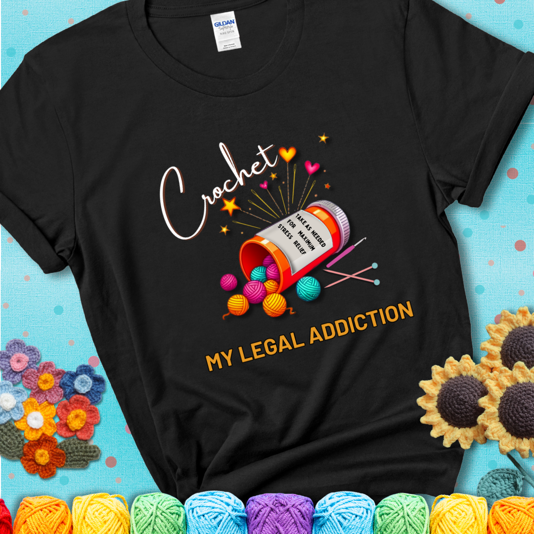 Black t-shirt with a prescription bottle spilling colorful yarn balls, small crochet details, and the phrase “Crochet: My Legal Addiction.”