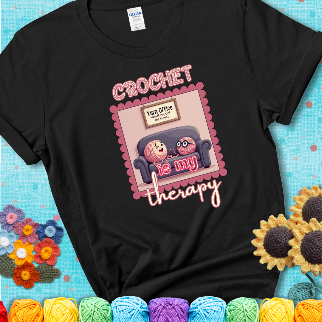 Black t-shirt showing a simple text design with yarn cartoon figures. Text reads: “Crochet is My Therapy.” A calming tee for fiber lovers who find healing in every stitch.