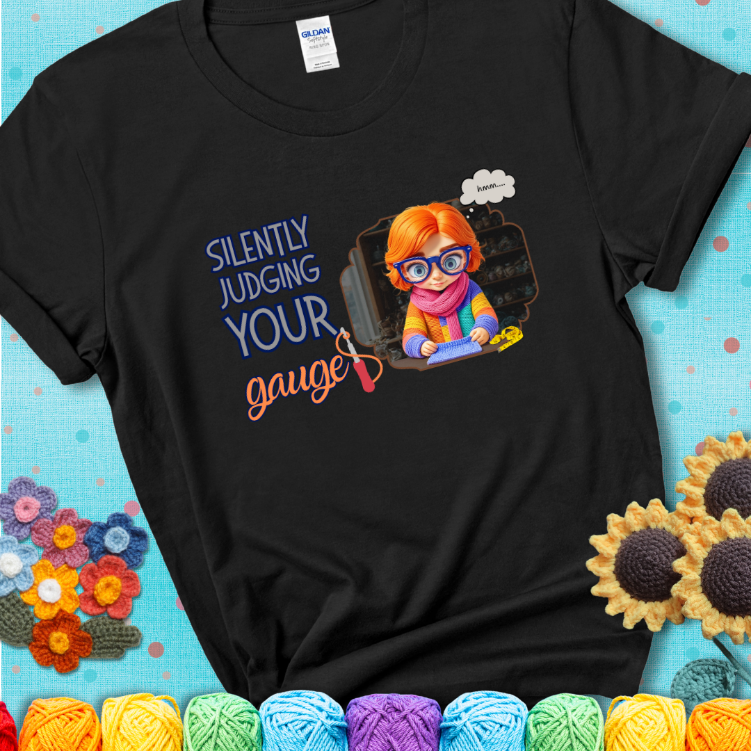 Black t-shirt with a serious-looking crocheter in rainbow clothing and big glasses, holding a tape measure under the phrase “Silently Judging Your Gauge.”