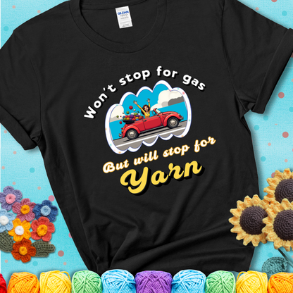 Black t-shirt with a woman driving a red convertible filled with yarn and the phrase “Won't Stop For Gas But Will Stop For Yarn.”