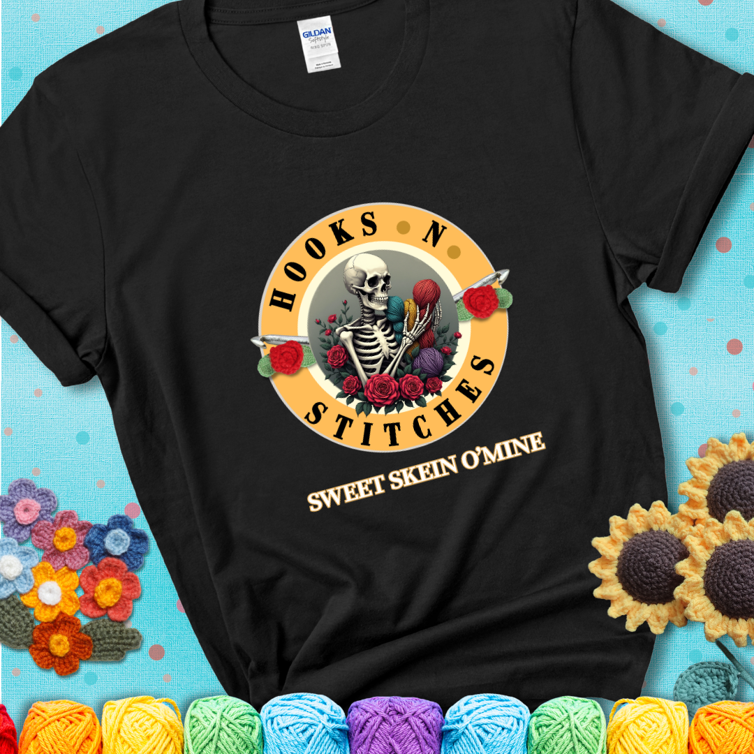 Black t-shirt with a skeleton holding colorful yarn, roses, crochet hooks, and the phrases “Hooks ’N Stitches” and “Sweet Skein O’Mine.”