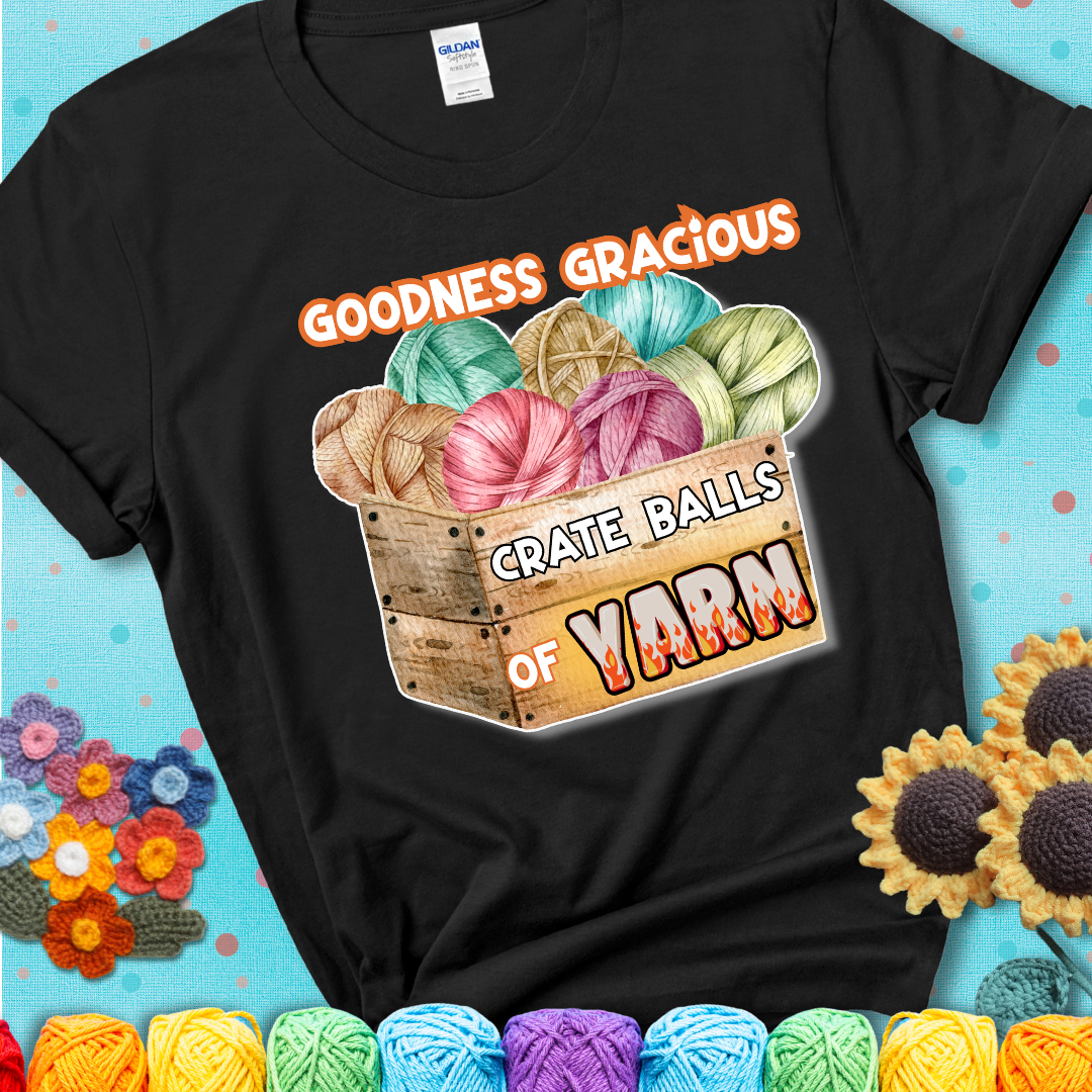 Wooden crate filled with colorful yarn balls and bold text “Goodness Gracious, Crate Balls of Yarn” with flame effects, a funny gift for crocheters showing a black tee with a teal sunflower background