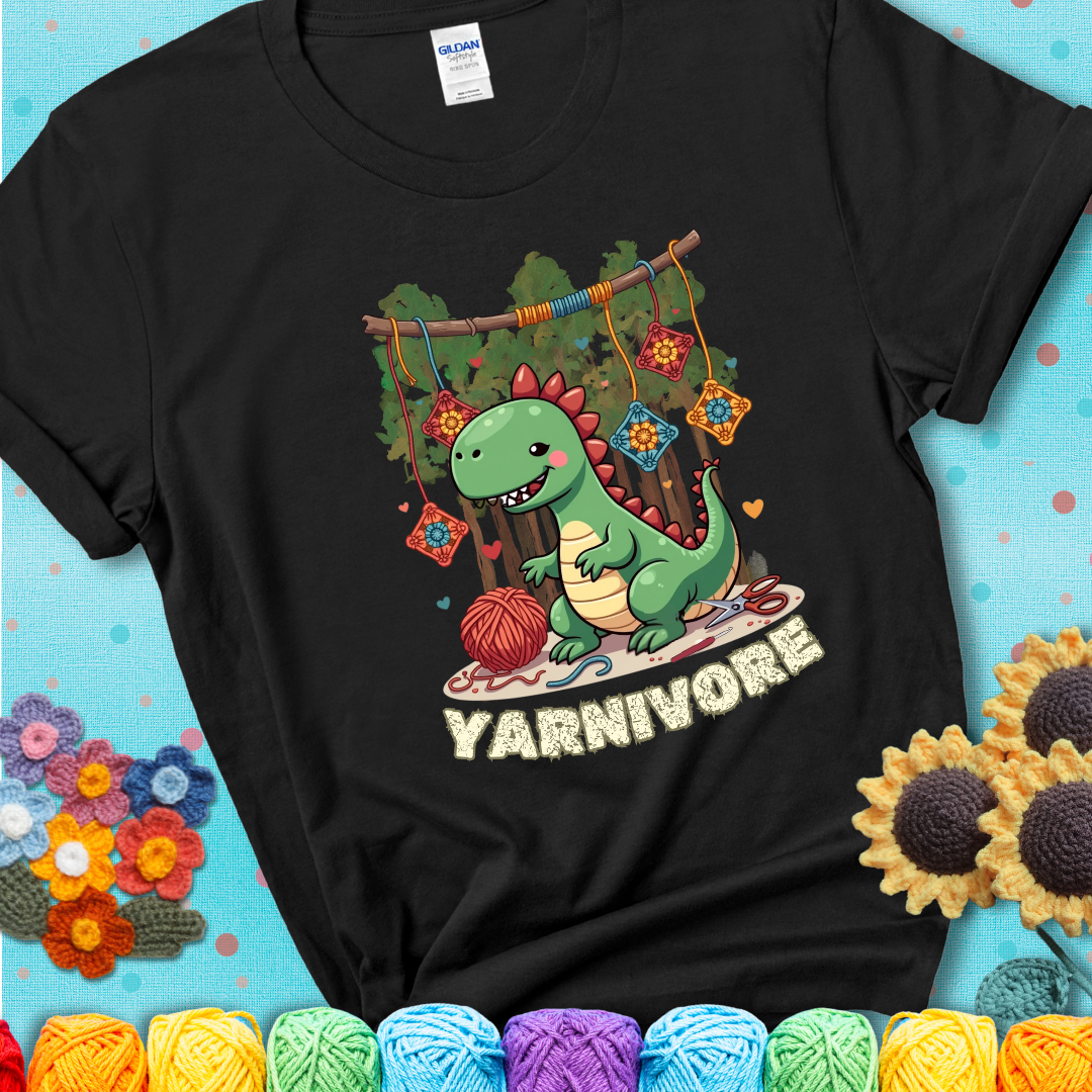 Black t-shirt shows a cute green dinosaur with yarn ball and granny squares, text “Yarnivore”, a fun crochet shirt for dino and yarn fans.