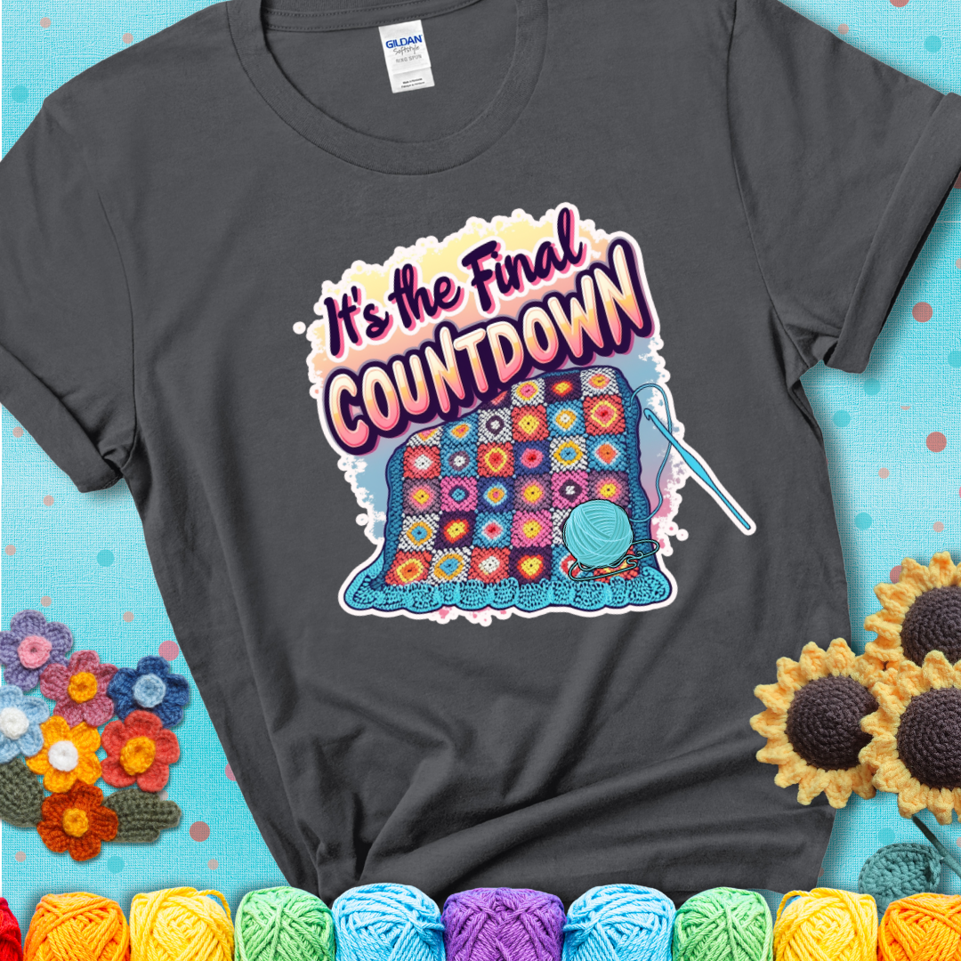 Charcoal t-shirt with a colorful crochet blanket in progress, blue yarn ball, crochet hook, and the phrase “It’s The Final Countdown.”