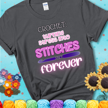 When life gets tangled, we stitch it out Design reads 'Crochet: Turning Stress Into Stitches Since Forever' , perfect crochet gift for yarn lovers; showing a charcoal grey tee with a teal sunflower background