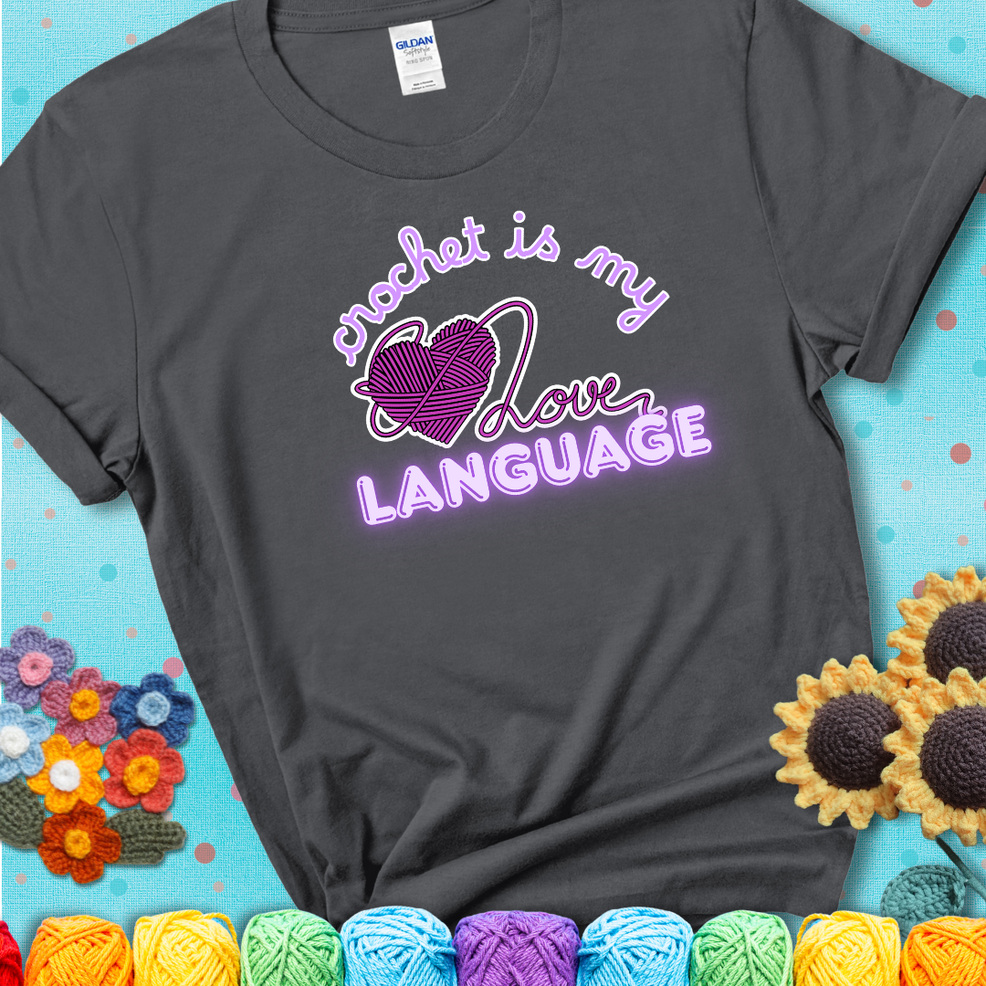 Say it with stitches Design reads 'Crochet Is My Love Language', perfect crochet gift for yarn lovers; showing a charcoal grey tee with a teal sunflower background