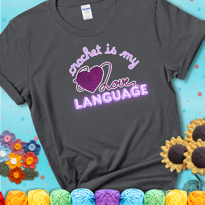 Say it with stitches Design reads 'Crochet Is My Love Language', perfect crochet gift for yarn lovers; showing a charcoal grey tee with a teal sunflower background