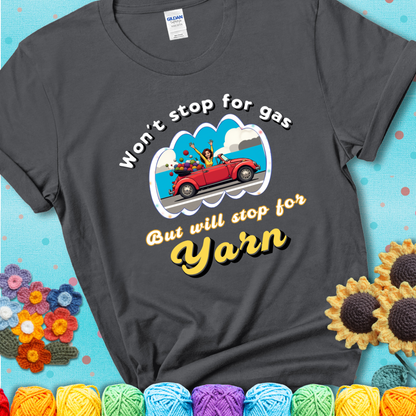 Charcoal t-shirt with a woman driving a red convertible filled with yarn and the phrase “Won't Stop For Gas But Will Stop For Yarn.”