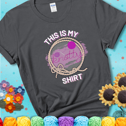 Charcoal t-shirt with the phrase “This is My Knotty Shirt” inside a rope circle, featuring a yarn ball and crochet hook forming the word “knotty.”