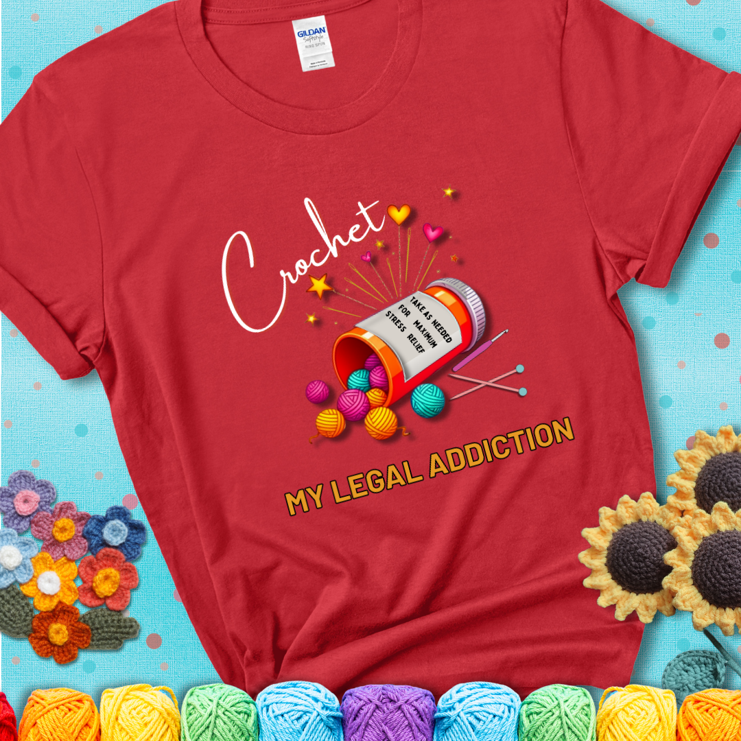 Red t-shirt with a prescription bottle spilling colorful yarn balls, small crochet details, and the phrase “Crochet: My Legal Addiction.”