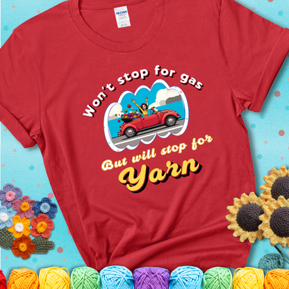 Red t-shirt with a woman driving a red convertible filled with yarn and the phrase “Won't Stop For Gas But Will Stop For Yarn.”