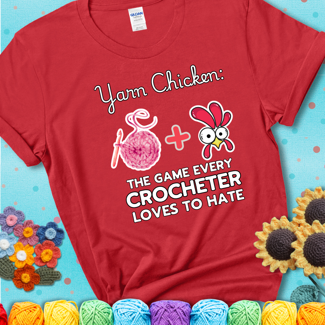 Cartoon chicken inside a yarn ball with crochet circle background. Text reads: “Yarn Chicken: The Game Every Crocheter Loves to Lose.” A fun and relatable tee for fiber artists who like to live on the edge, showing a red tee with a teal sunflower background