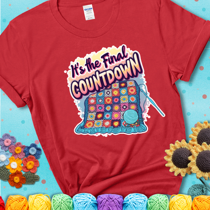 Red t-shirt with a colorful crochet blanket in progress, blue yarn ball, crochet hook, and the phrase “It’s The Final Countdown.”
