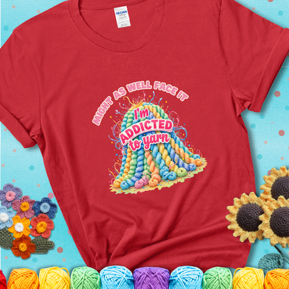Red t-shirt with a colorful mountain of pastel yarn hanks and the phrase “Might As Well Face It, I’m Addicted To Yarn” in pink and red lettering.