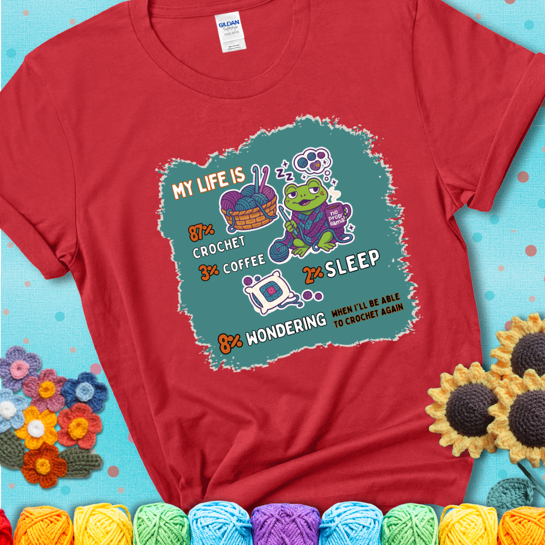 Red t-shirt with a crocheting frog, coffee, yarn, and text showing a playful life breakdown: 87% crochet, 3% coffee, 2% sleep, 8% wondering when to crochet again.