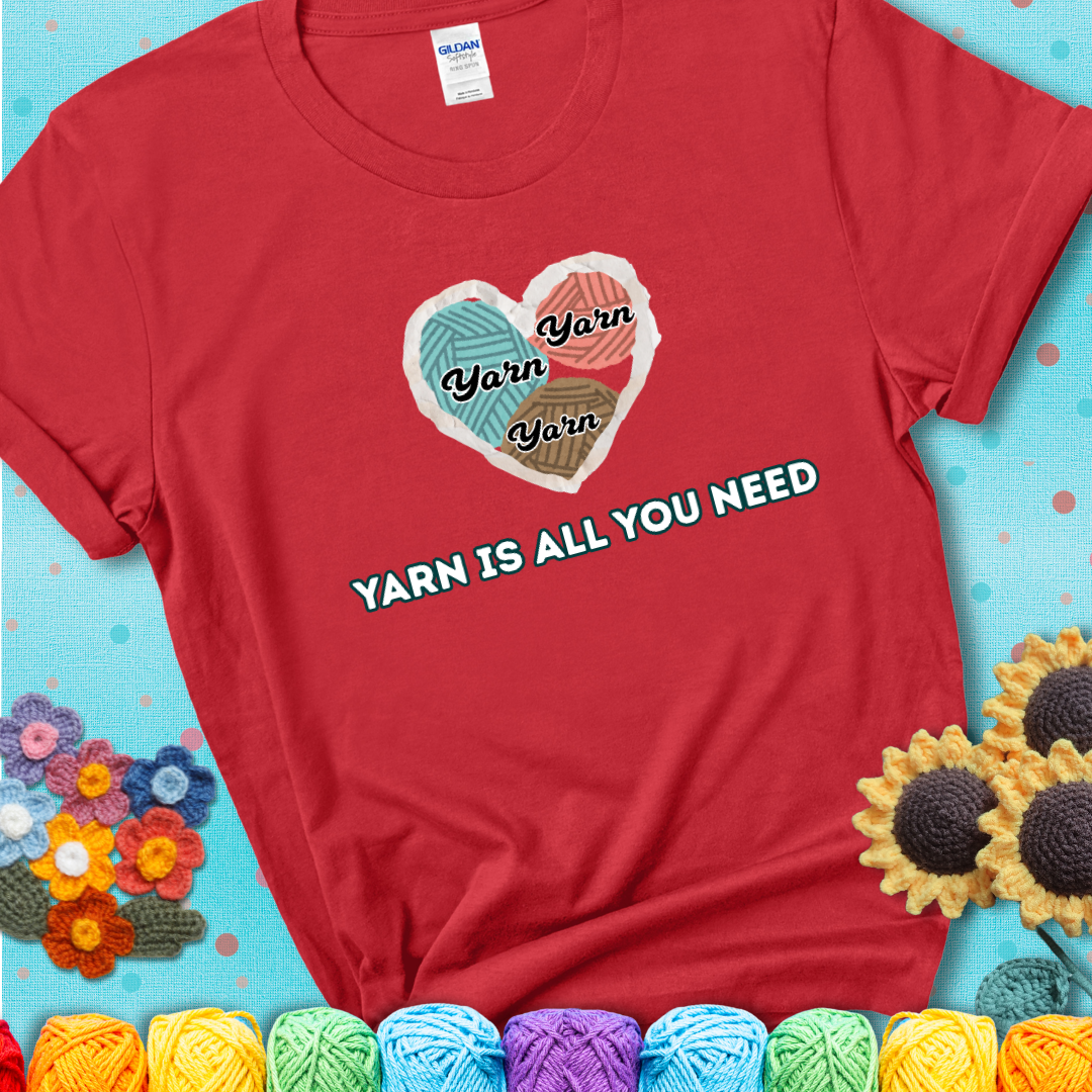 Red t-shirt with a colorful heart made of yarn textures and the phrase “Yarn Is All You Need” in retro lettering.