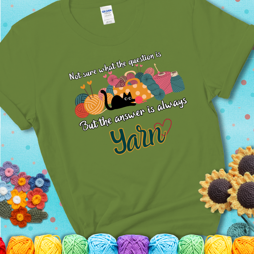 Kiwi green t-shirt with a black cat beside a basket of colorful yarn and the phrase, “Not Sure What The Question Was, But The Answer Is Yarn.”