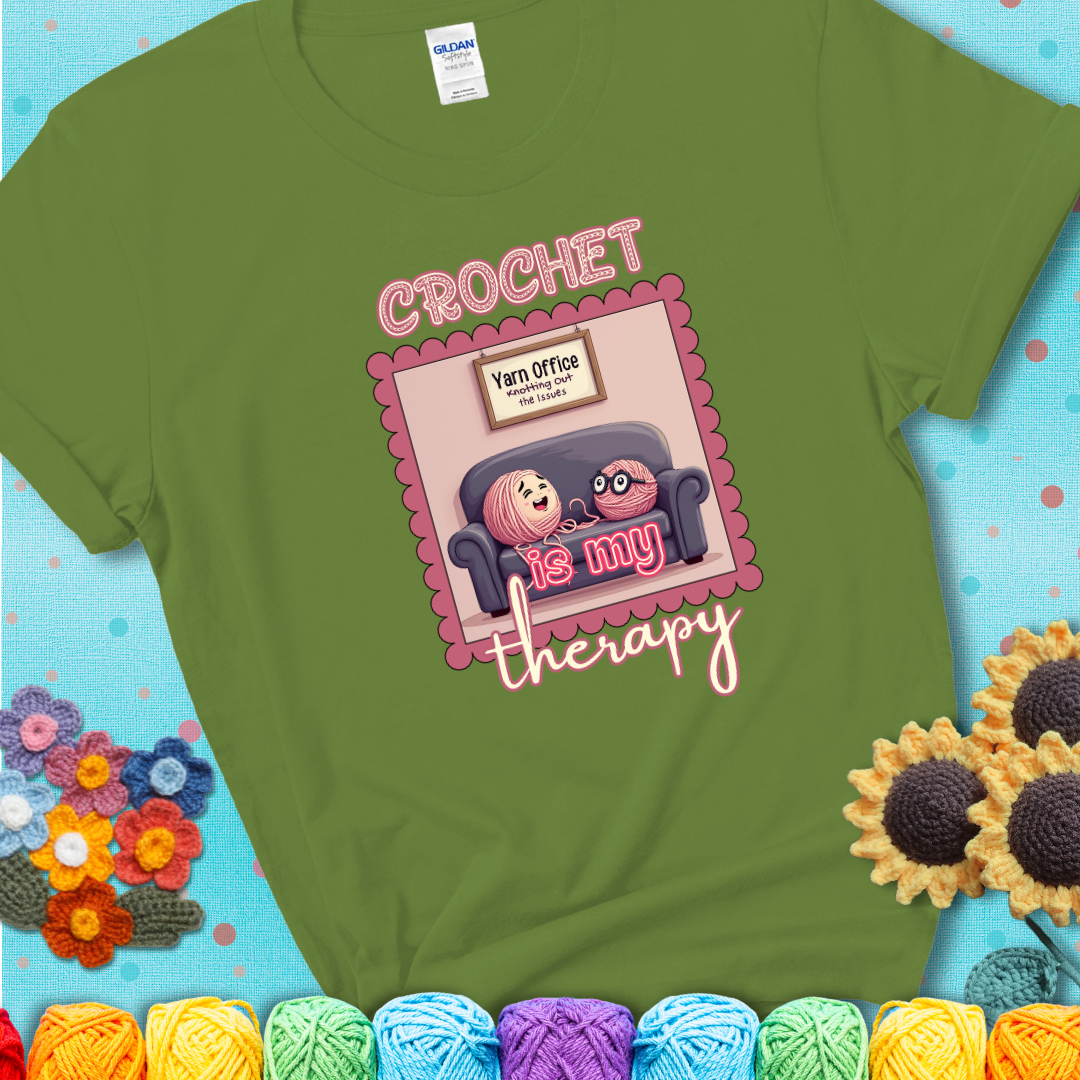 Green t-shirt showing a simple text design with yarn cartoon figures. Text reads: “Crochet is My Therapy.” A calming tee for fiber lovers who find healing in every stitch.