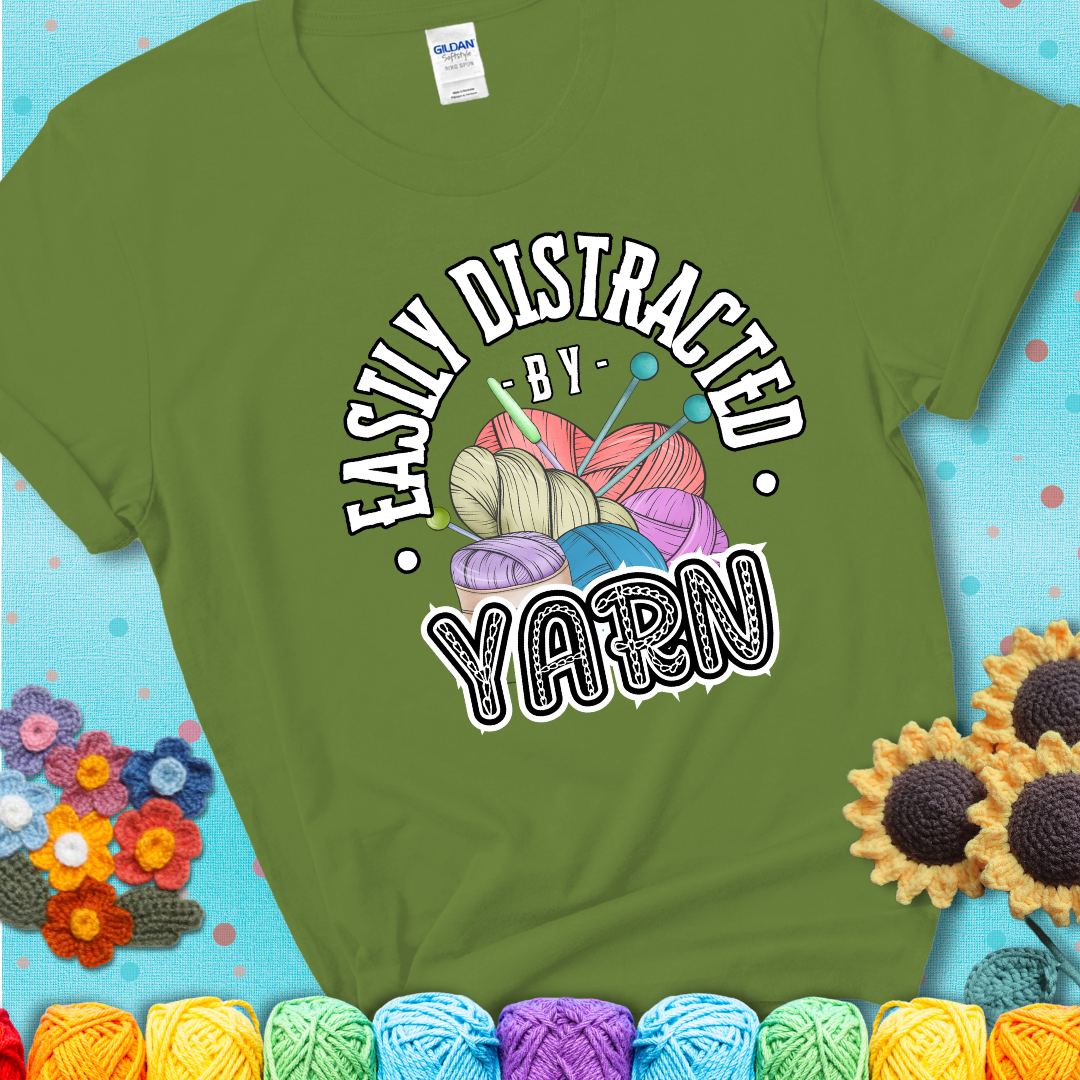 If yarn steals your focus every Design reads 'Easily Distracted By Yarn', perfect crochet gift for yarn lovers; showing a green tee with a teal sunflower background