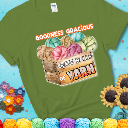 Wooden crate filled with colorful yarn balls and bold text “Goodness Gracious, Crate Balls of Yarn” with flame effects, a funny gift for crocheters showing a green tee with a teal sunflower background