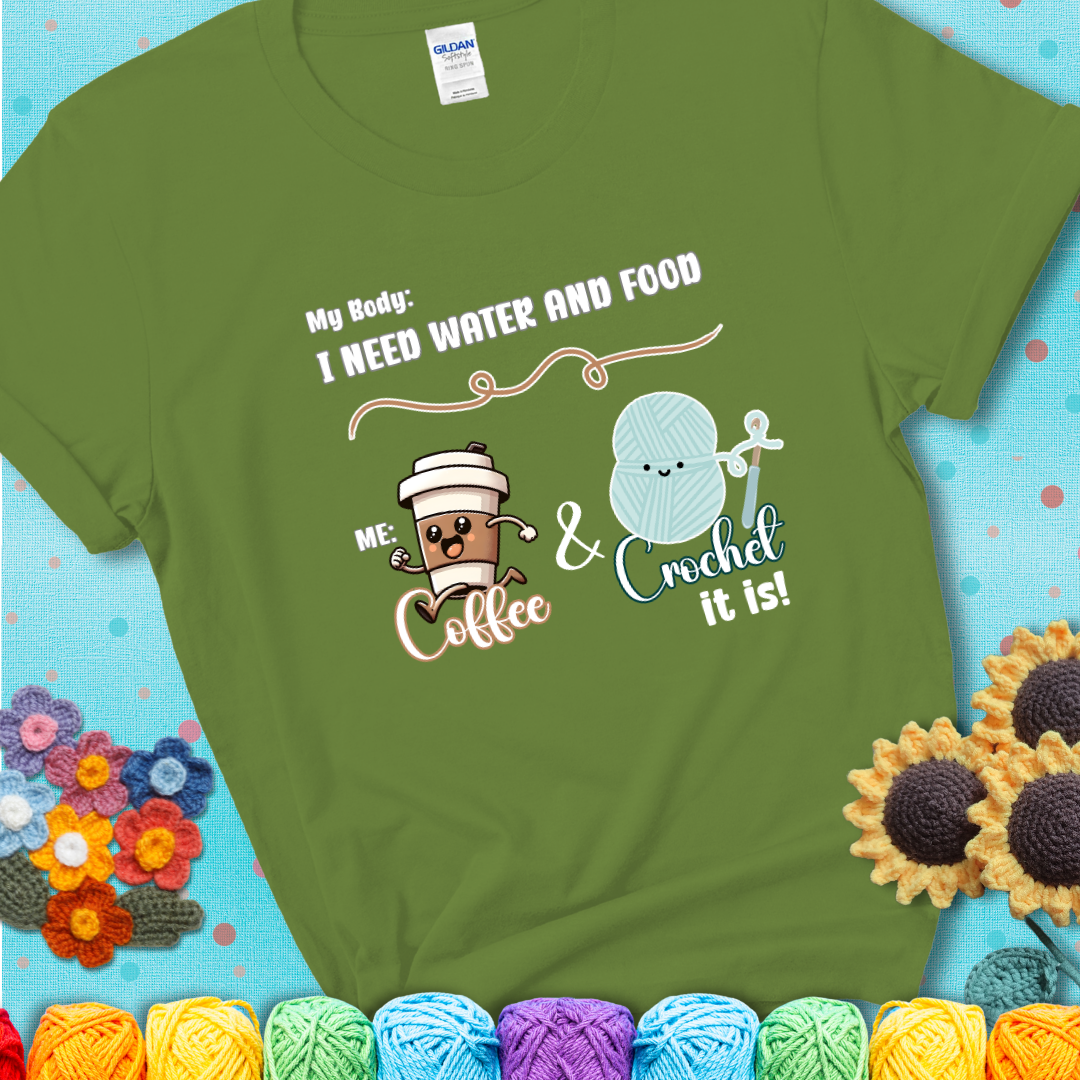 Design reads “My body: I need water and food. Me: Coffee & Crochet it is,” with a smiling coffee cup and yarn ball characters on a green t-shirt.