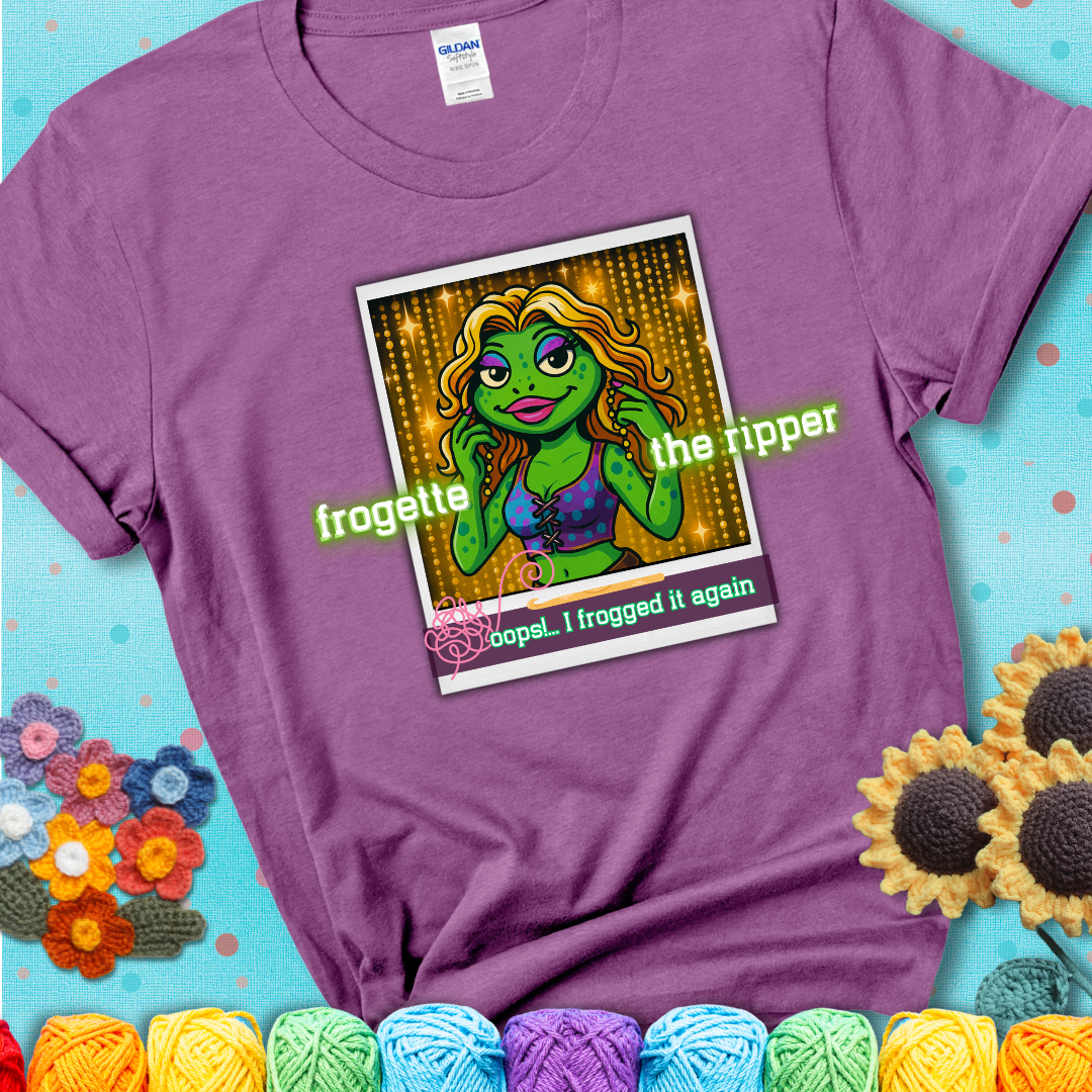 Retro-styled illustration of a glamorous green frog in a sparkly outfit, labeled "Frogette the Ripper" with the phrase “Oops! I frogged it again” below, referencing both crochet and pop culture showing a lavender tee with a teal sunflower background