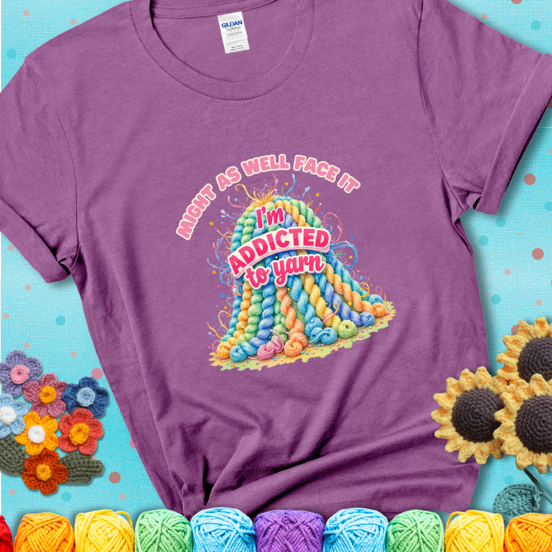 Heather Radiant Orchid t-shirt with a colorful mountain of pastel yarn hanks and the phrase “Might As Well Face It, I’m Addicted To Yarn” in pink and red lettering.