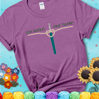 Hooked on yarn? Same Design reads 'Get Hooked, Stay Knotty' , perfect crochet gift for yarn lovers, showing a lavender tee with a teal sunflower background