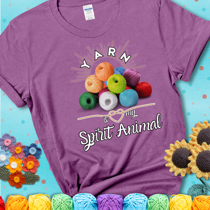 Stack of colorful yarn balls with radiant glow. Text reads: “Yarn Is My Spirit Animal.” A calming and colorful tee for fiber lovers who find zen in stitching, showing a lavender tee with a teal sunflower background