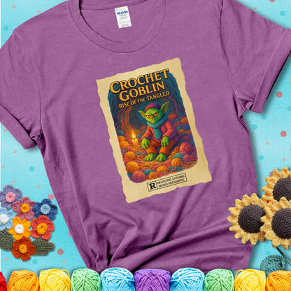 Crochet goblin surrounded by chaotic yarn stash in a cave-like lair. Text reads: “Crochet Goblin: Rise of the Tangled.” A funny fantasy-style light purple tee for yarn hoarders and goblin-mode crafters.