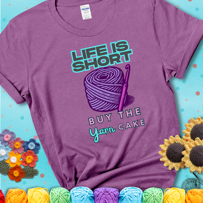 No regrets, just yarn. Design reads 'Life Is Short. Buy The Yarn (Cake)' , perfect crochet gift for yarn lovers, showing a lavender tee with a teal sunflower background