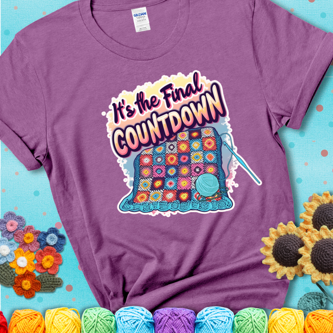 Heather Radiant Orchid t-shirt with a colorful crochet blanket in progress, blue yarn ball, crochet hook, and the phrase “It’s The Final Countdown.”