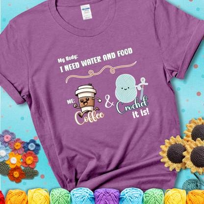 Design reads “My body: I need water and food. Me: Coffee & Crochet it is,” with a smiling coffee cup and yarn ball characters on a light purple t-shirt.